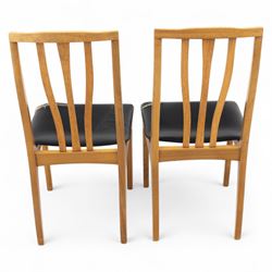 Sutcliffe of Todmorden - mid 20th century ‘S-Form’ teak dining table and chairs, the circular storable extending table with plain veneered top on tapered supports, together with matching dining chairs upholstered in black vinyl, with curved slat backs and shaped front supports, reflecting the sleek organic styling characteristic of 1960s British modern furniture design (Chairs H 93cm, W 46cm, D 46cm) (Extended 168cm)