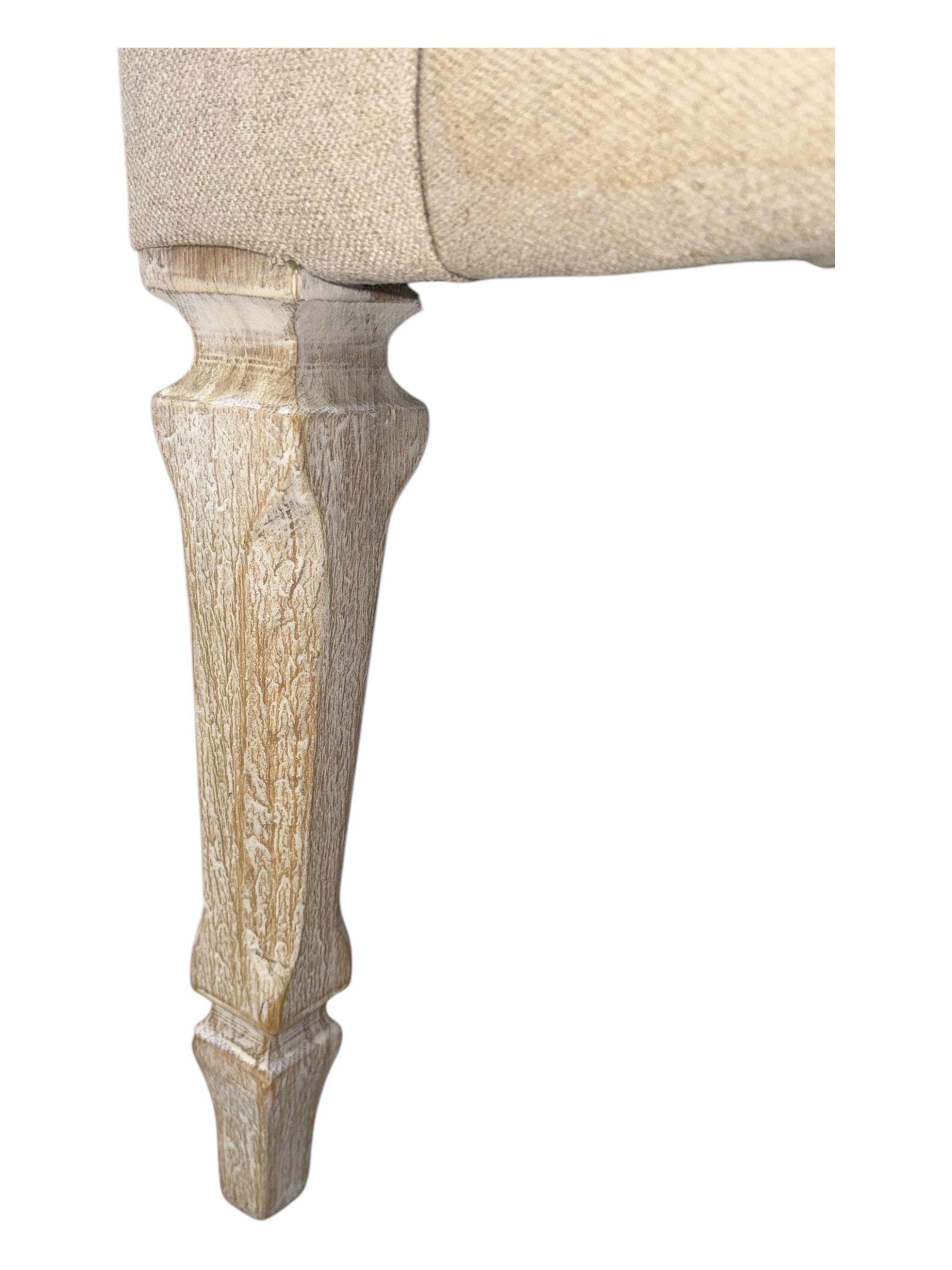 Pair of contemporary hardwood corner chairs, upholstered in broad alternating bands of neutral-toned fabric, each with two knotted rope buttons to the backrest, the whole raised on turned and lightly whitewashed supports terminating in castors