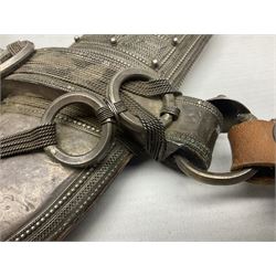 Omani Khanjar dagger, the 19cm curved blade with pronounced medial rib to either side, waisted hilt with dome shaped pommel and silver covered horn grip decorated with filigree bands, floral motifs and beadwork; in an intricately filigree decorated silver and leather scabbard with silver rings woven into the belt mount and fitted with original silver thread-work belt L34cm overall belt length 94cm