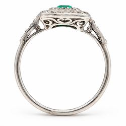 Early 20th century palladium emerald and diamond halo cluster ring, single rectangular cut emerald of approx 0.30 carat, surrounded by two rows of milgrain set diamonds and diamond set shoulders