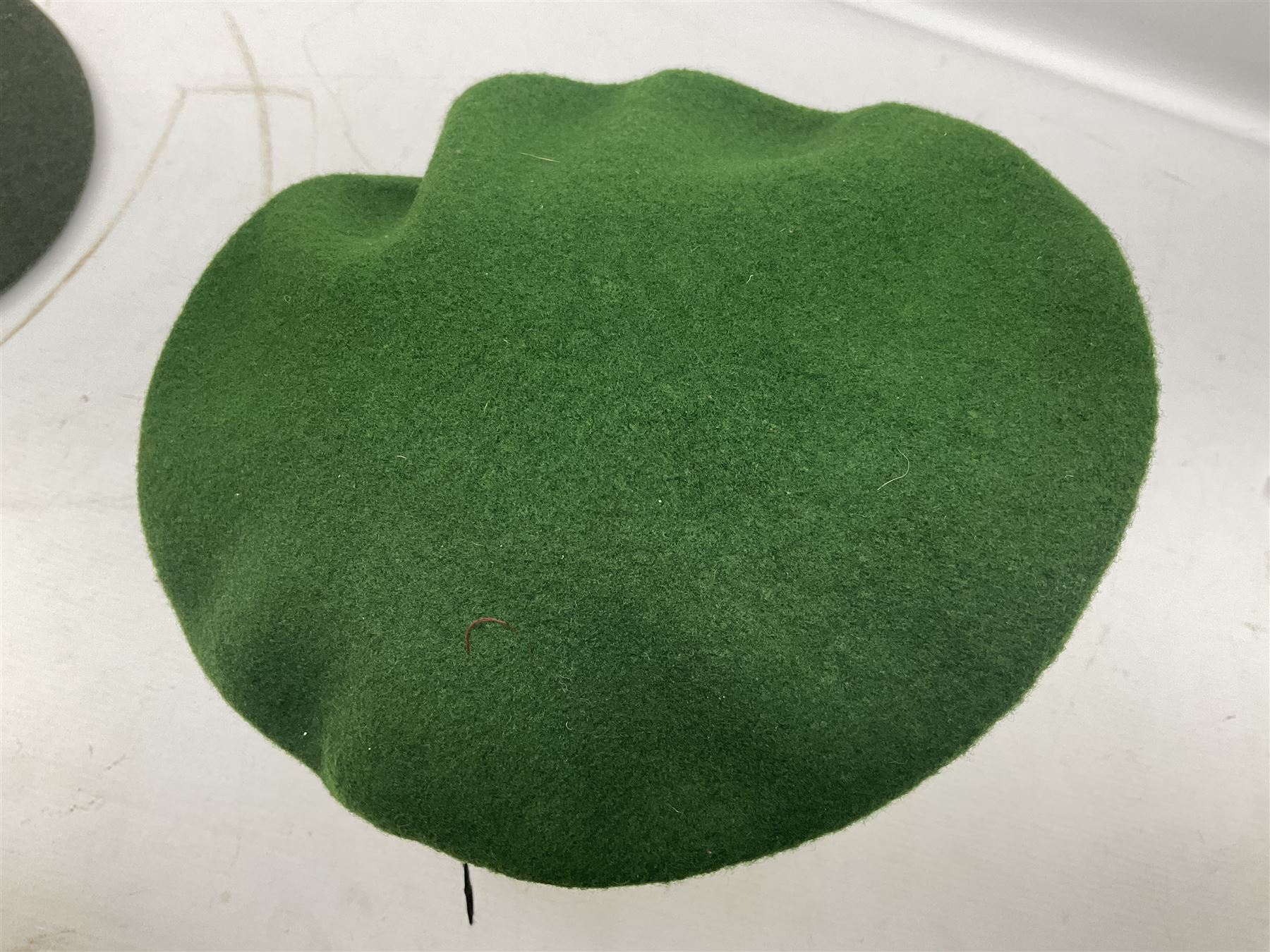 Four paratrooper berets - Russian, Italian, British and Foreign Legion; all with badges (4)