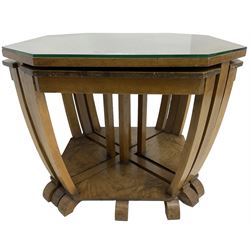 1930s Art Deco period walnut nest of tables, square canted top with segmental figured veneers forming flowerhead with birdseye maple centre, with four smaller nesting tables on arched supports united by undertier, on block feet
