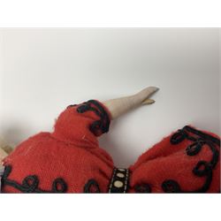  Victorian wax bonnet head doll with moulded red brimmed beret, applied hair and black glass eyes, stuffed body and wooden lower limbs with black painted boots, dressed in red and black trouser suit H31cm