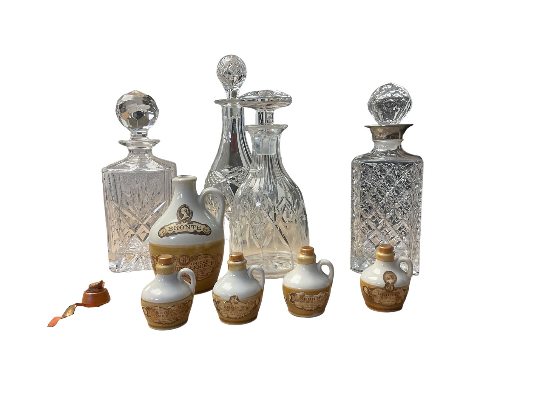 Four glass decanters, together with an empty Bronte Yorkshire Liqueur flagon and four miniatures 