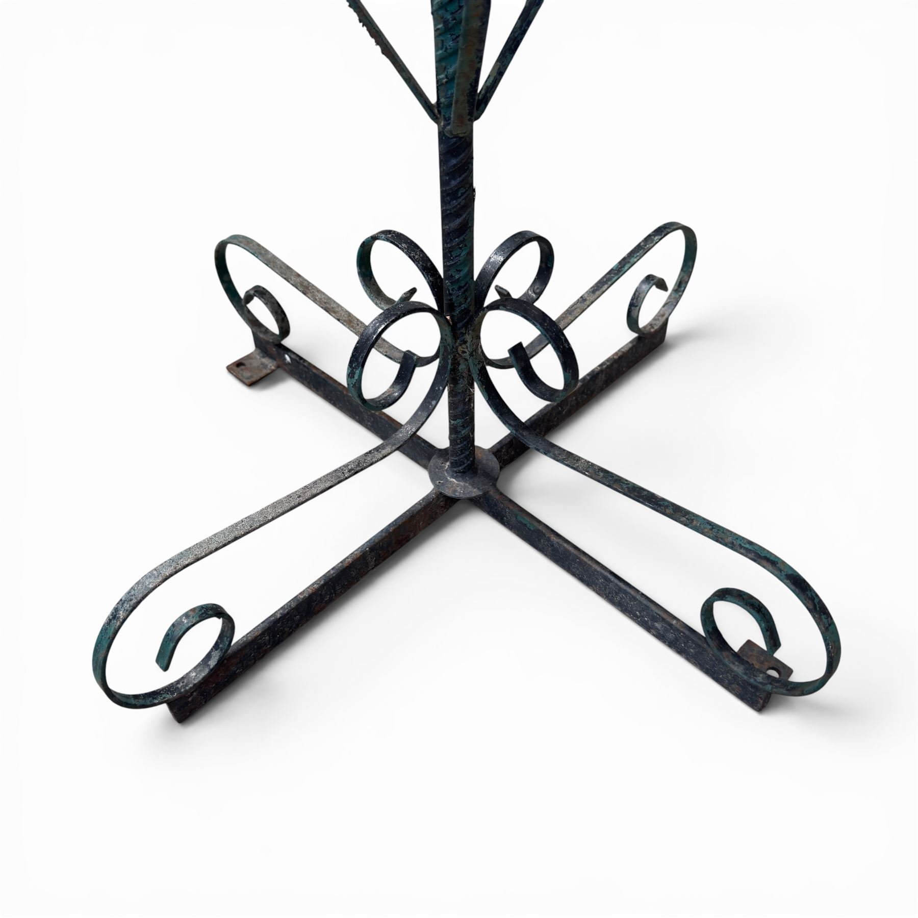 Matched pair of antique metal plant stands, each with circular strapwork basket tops, the scrollwork supports raised on an X-form base, in green painted finish with rustic patina