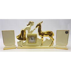  French Art Deco Berlot & Mussier, ODYV clock garniture, the clock moulded as a girl feeding a deer, both having gilt decoration with two vases, bearing original label   