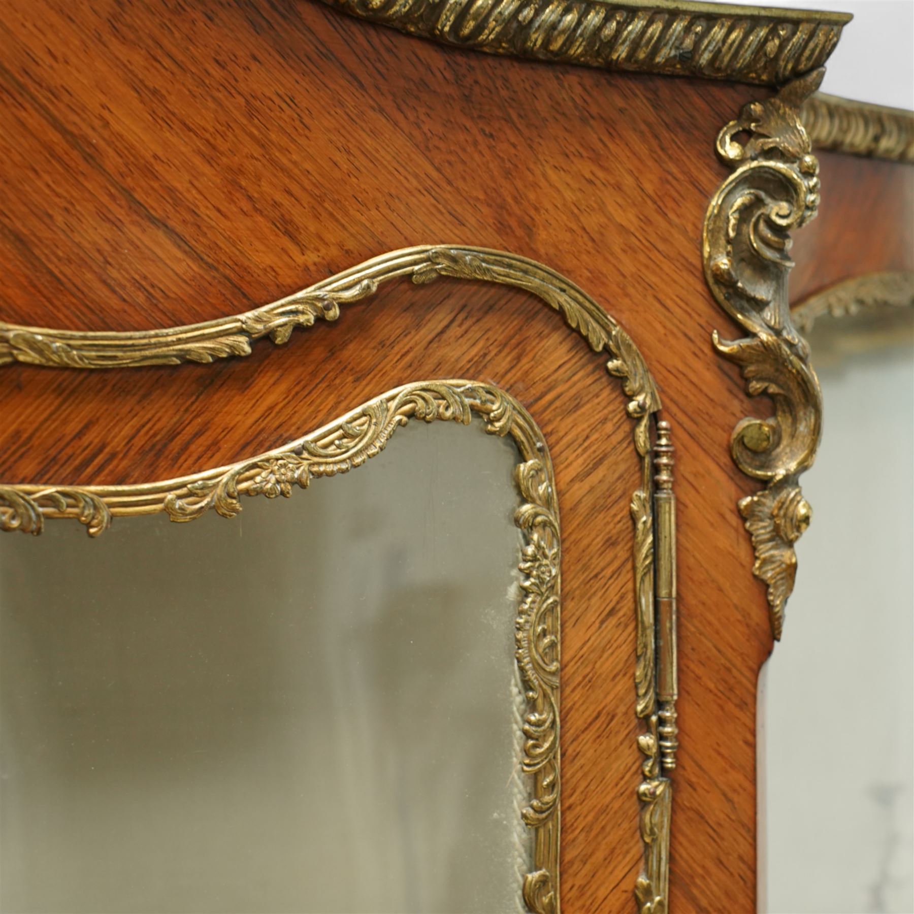 Louis XV revival kingwood Vernis-Martin serpentine fronted vitrine cabinet, arched top with gilt brass foliate mounts, glazed door with two shelves above three painted panels, depicting pastoral scenes, supported on out-swept cabriole legs with gilt brass mounts and sabots.