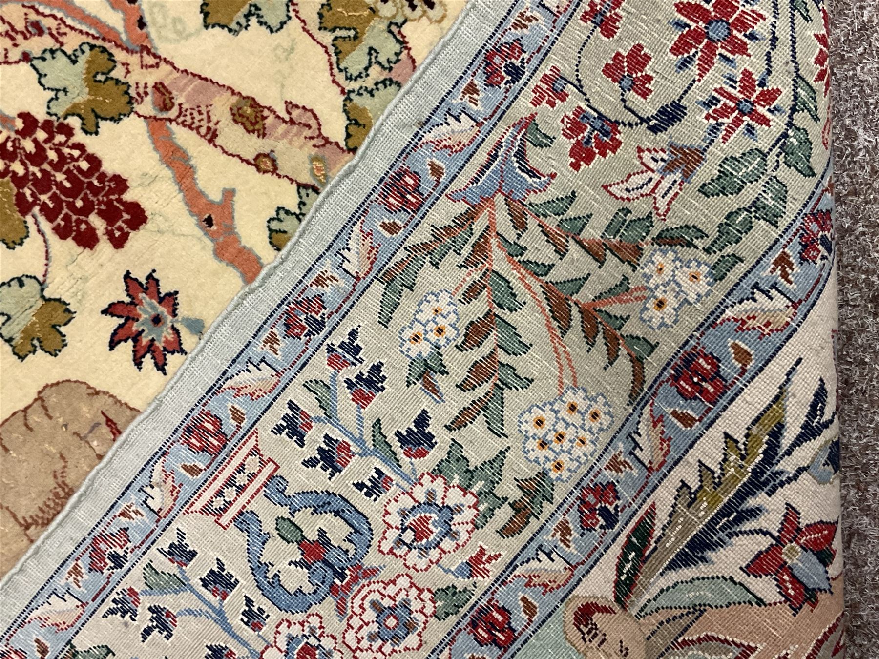 Fine Persian tree of life rug wall hanging, ivory ground field depicting landscape filled with animals, birds and flowers, the guarded border with stylised flower heads and foliage decoration, with brass hanging rail