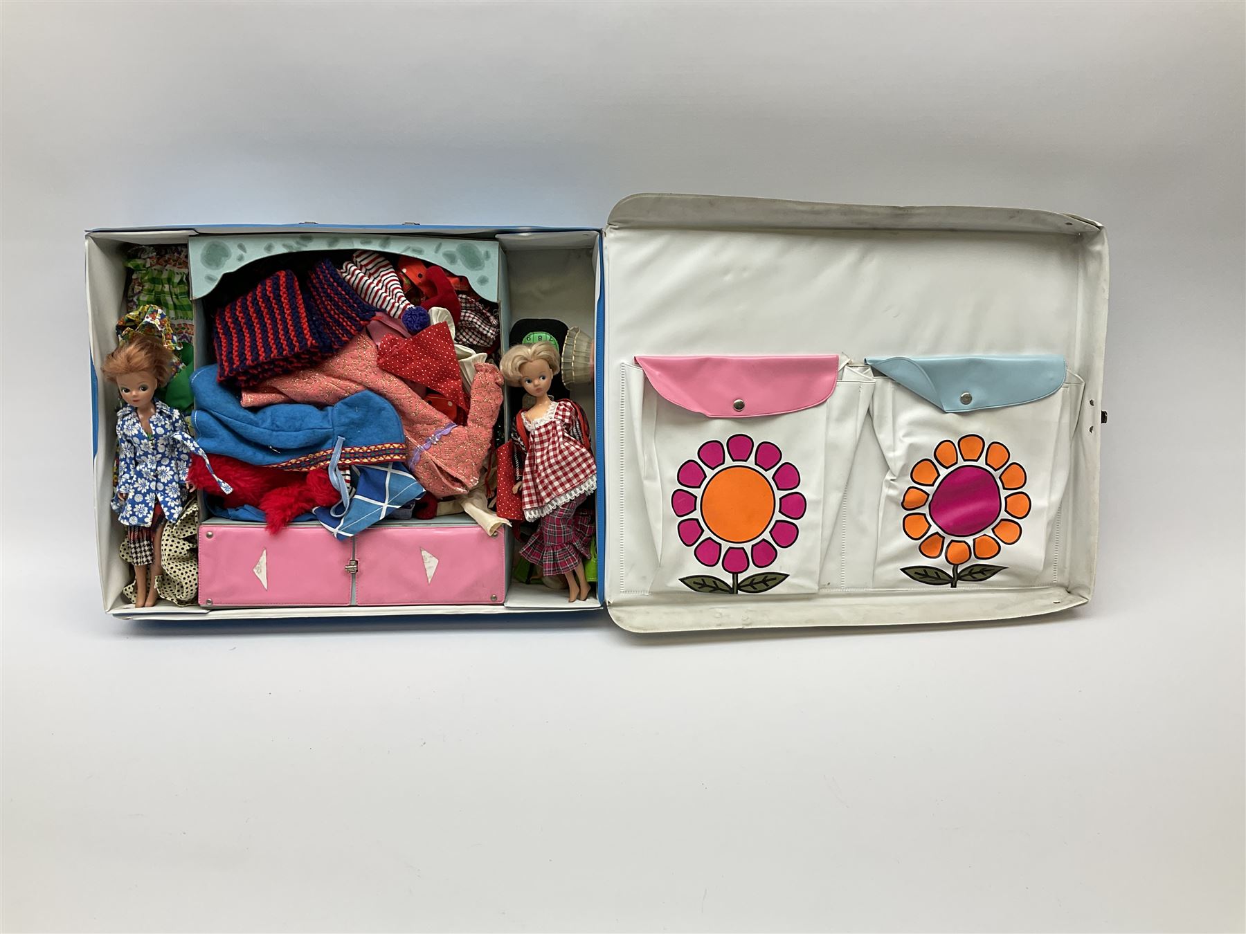 The World of Barbie Double Doll Case containing a quantity of assorted doll's clothing; together with two large and one small fashion dolls.