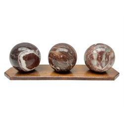 Set of three marble spheres on a elongated octagonal wooden base, H12cm