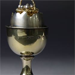 Late 20th century silver-gilt novelty surprise egg by Anthony Gordon Elson, the egg cup containing a  removeable shell, lifting to reveal a parcel gilt egg basket beneath, hallmarked Anthony Gordon Elson, London 1979, H11cm