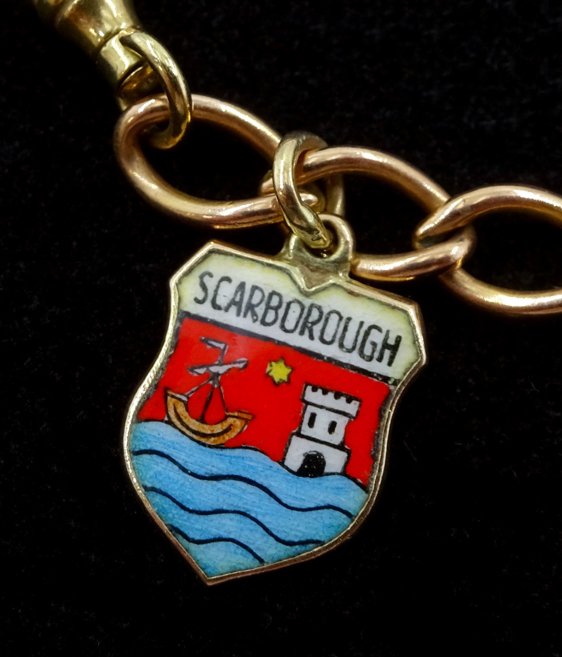 9ct rose gold curb link charm bracelet with yellow gold clip and four 9ct gold charms including, horseshoe, clown, bananas and enamel Scarborough charm