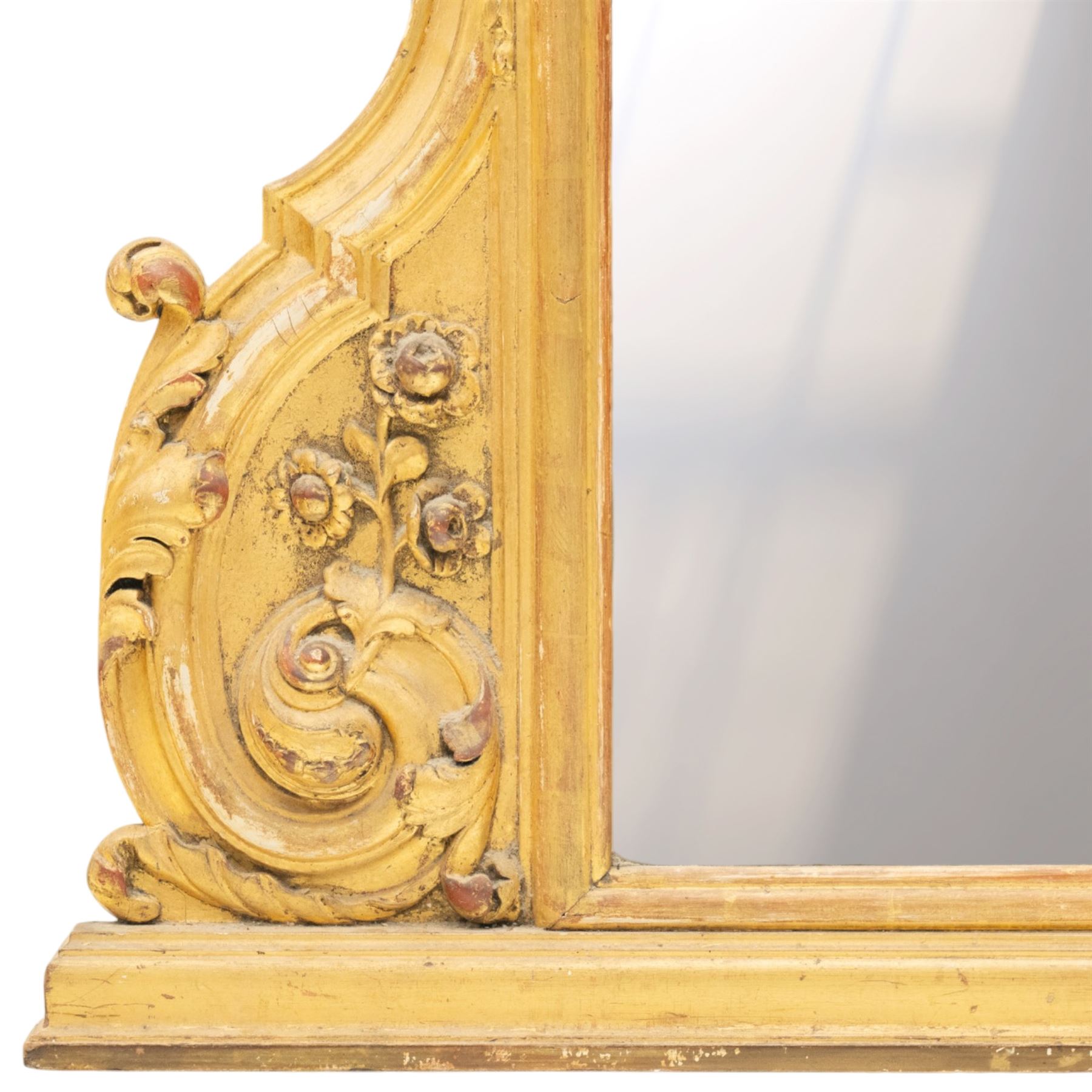 19th century Italian Baroque Revival carved giltwood and gesso wall mirror, the large acanthus leaf pediment flanked by C-scrolls and further acanthi motifs, enclosing a shaped arch plate with moulded slip, flanked by down-scrolls of acanthi with emerging flowering branches, on a stepped base