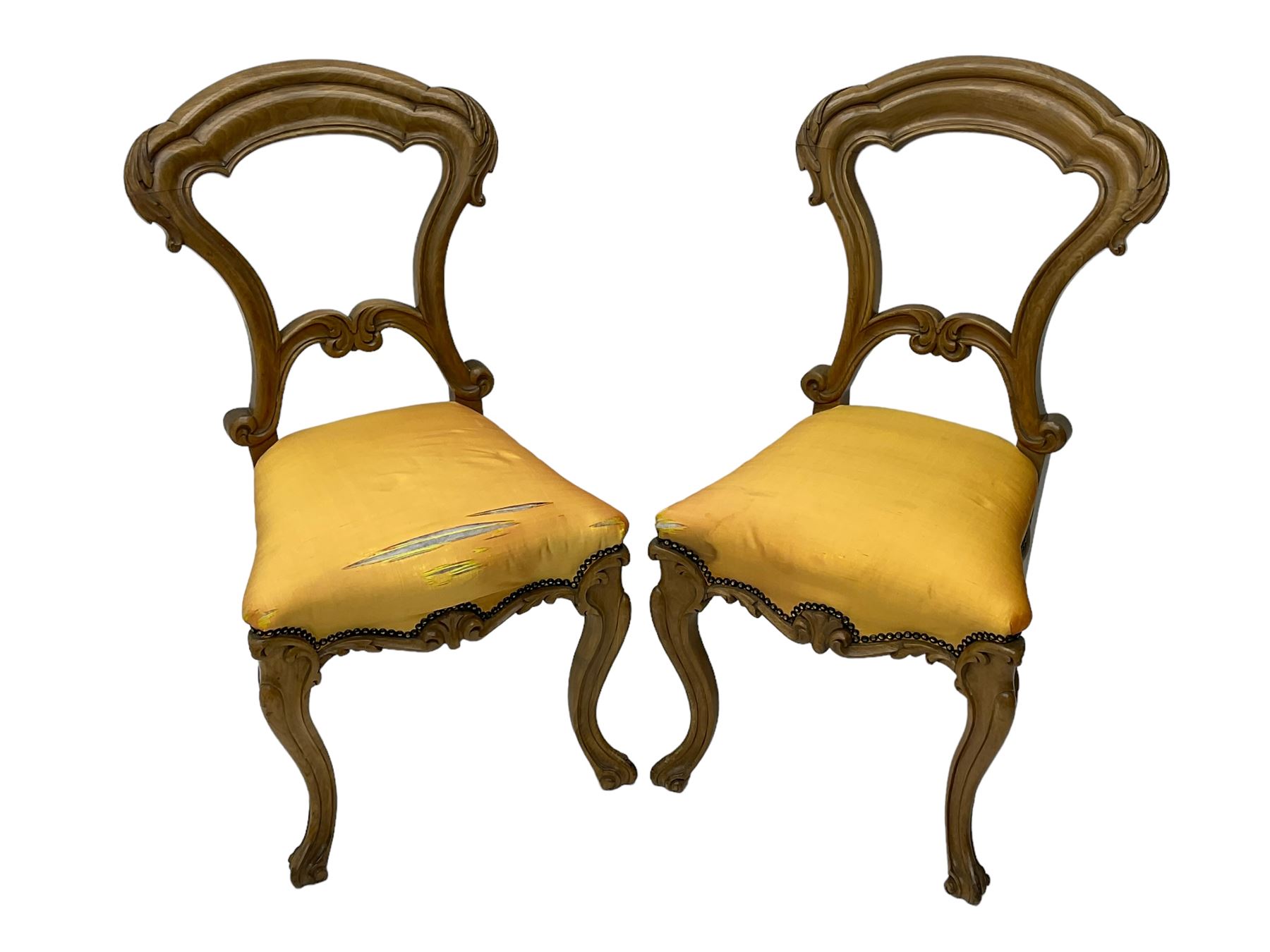 Pair of Victorian walnut side chairs, shaped cresting rail carved with acanthus leaves, overstuffed upholstered seats with stud band, on cabriole supports with scroll carved terminals
