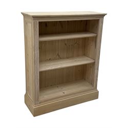 Contemporary light pine open bookcase, rectangular top with stepped moulded edge above a boarded back, fitted with two adjustable shelves, on a plinth base