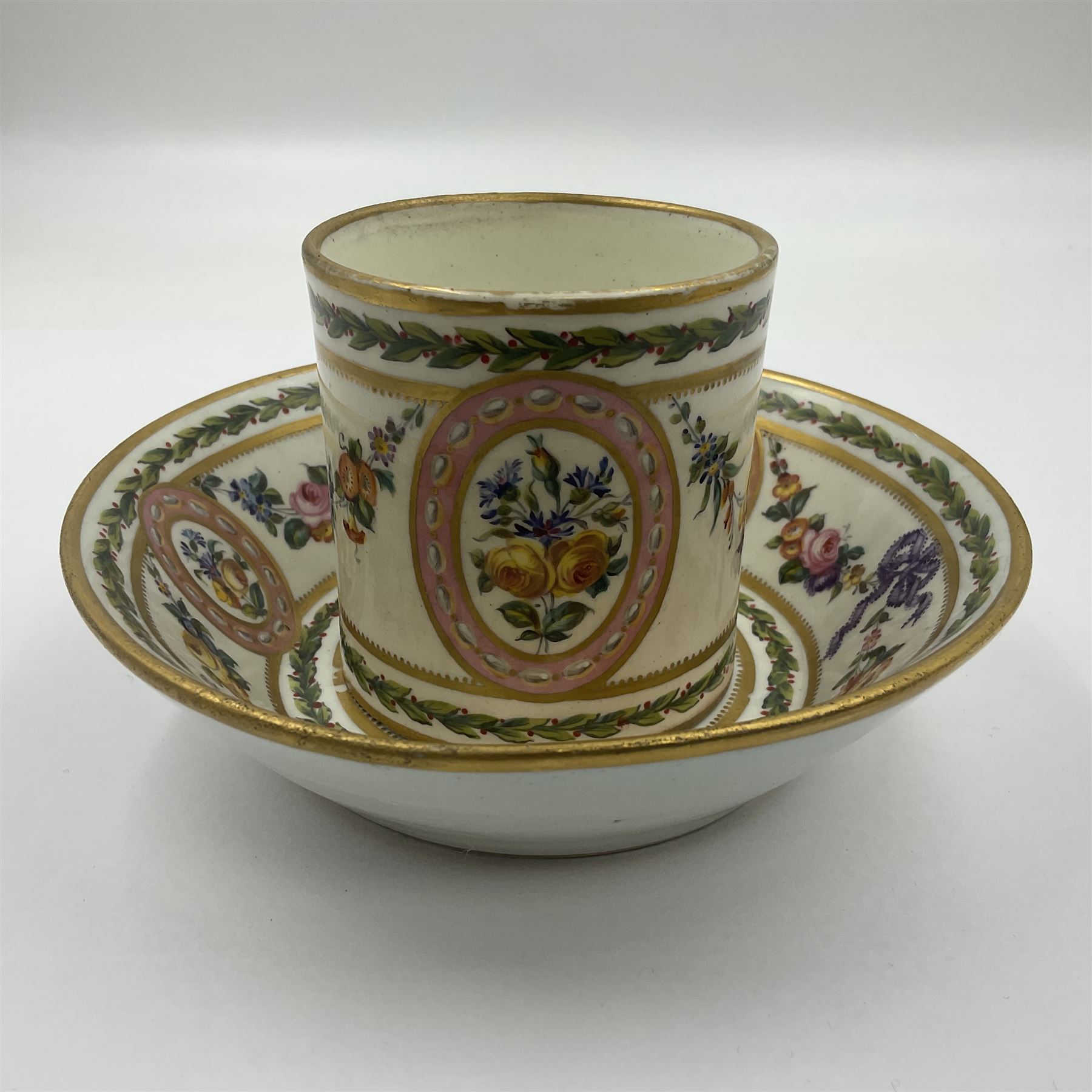 Sèvres soft paste porcelain coffee can and saucer with date code for 1780, painted with pink oval panels bordering bouquets of flowers, united by swags of flowers tied with purple ribbons, within laurel leaf borders, interlaced LL monogram enclosing date letters CC above painters marks for Nicquet, coffee can H7.5cm, saucer D15cm