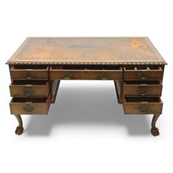 Waring & Gillow - Early 20th century mahogany desk, the leather-inset top above a shaped kneehole, central compartmented frieze drawer flanked by twin banks of of three drawers, each with brass handles, raised on cabriole legs with carved ball and claw feet (Height from floor to underside 62cm)