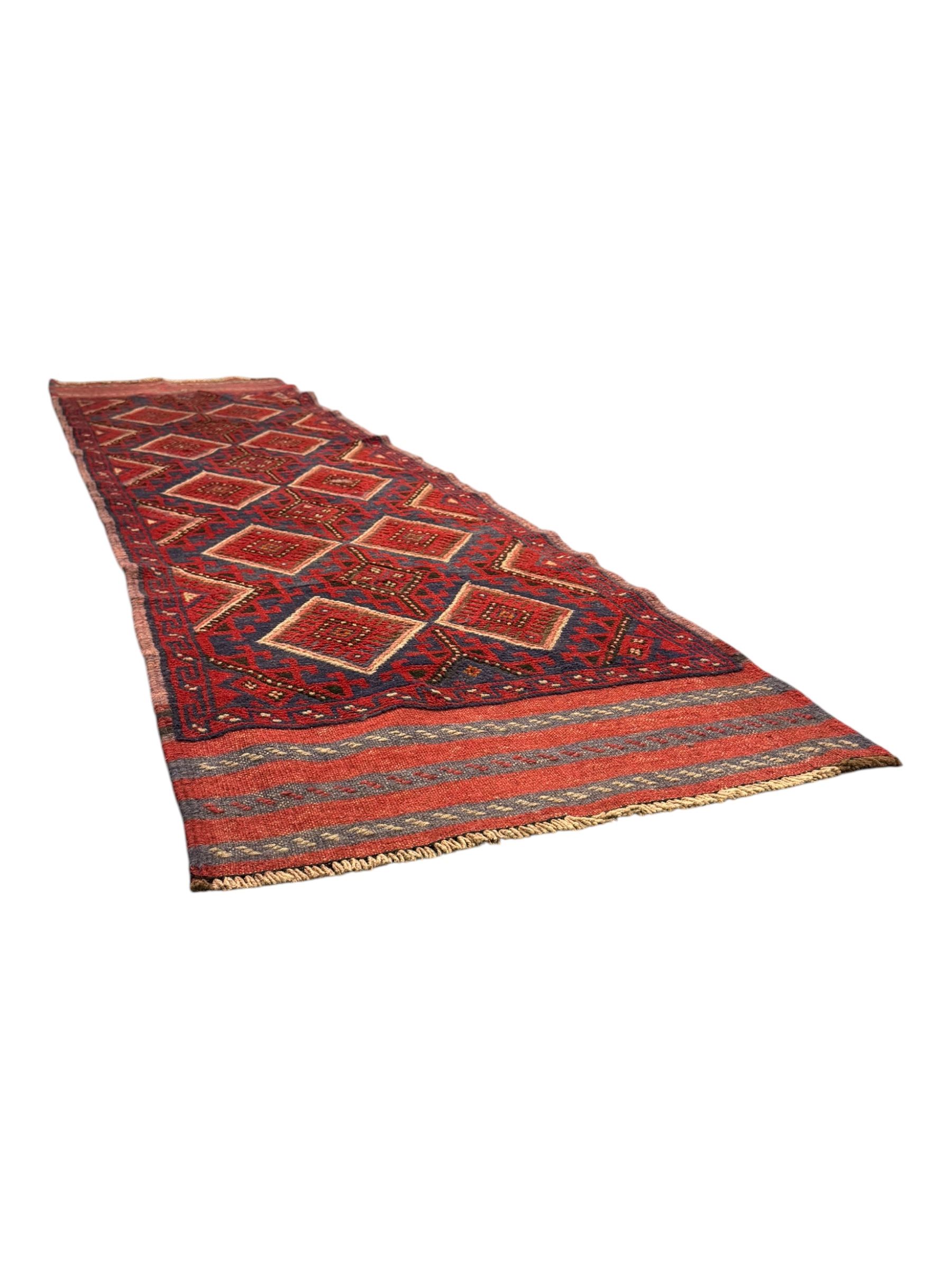 Pashtun Meshwani ground runner, central field decorated with rows of multicoloured diamond medallions, surrounded by geometric motifs, wide red and blue striped border with additional guard bands