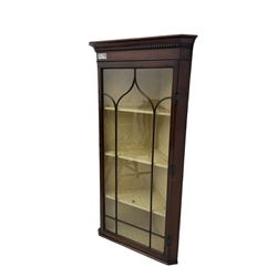 Early 20th century Georgian design mahogany wall-mounted corner display cabinet, projecting cornice with dentil frieze over astragal glazed door enclosing three fabric-lined shelves