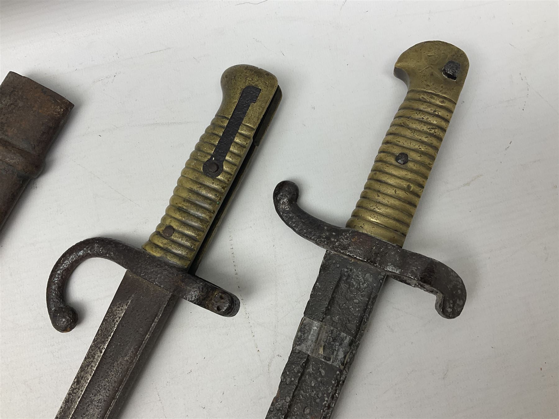 French Model 1874 Epee bayonet marked Oulle 1876 in associated scabbard; Model 1866 sabre bayonet in cut-down sword scabbard; and Model 1842/59 sabre bayonet in relic condition (3)
