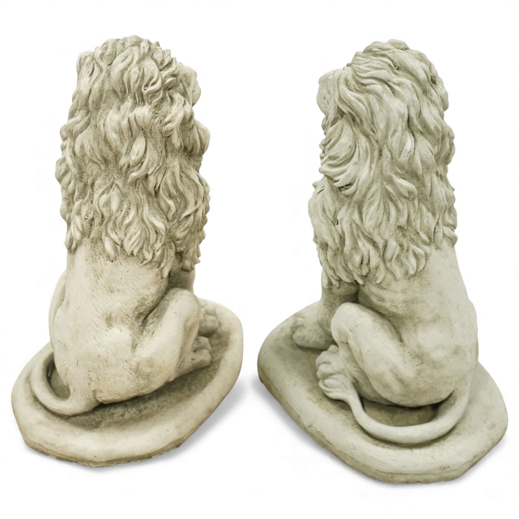 Pair of contemporary cast stone lions, seated pose on shaped plinths, with textured manes and aged surface finish