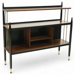E Gomme for G Plan - 'Librenza' mid-20th century teak and ebonized wood bookcase, rectangular three-tier open shelf design with finials, narrow and raised top shelf above full span and depth central shelf, above divided shelf with open pigeonholes, sides with brass rods, raised on tapering legs with brass capped feet
