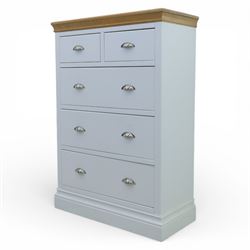 Modern chest of two short and three long drawers in white finish with oak moulded top, with metal cup handles, raised on a moulded plinth base