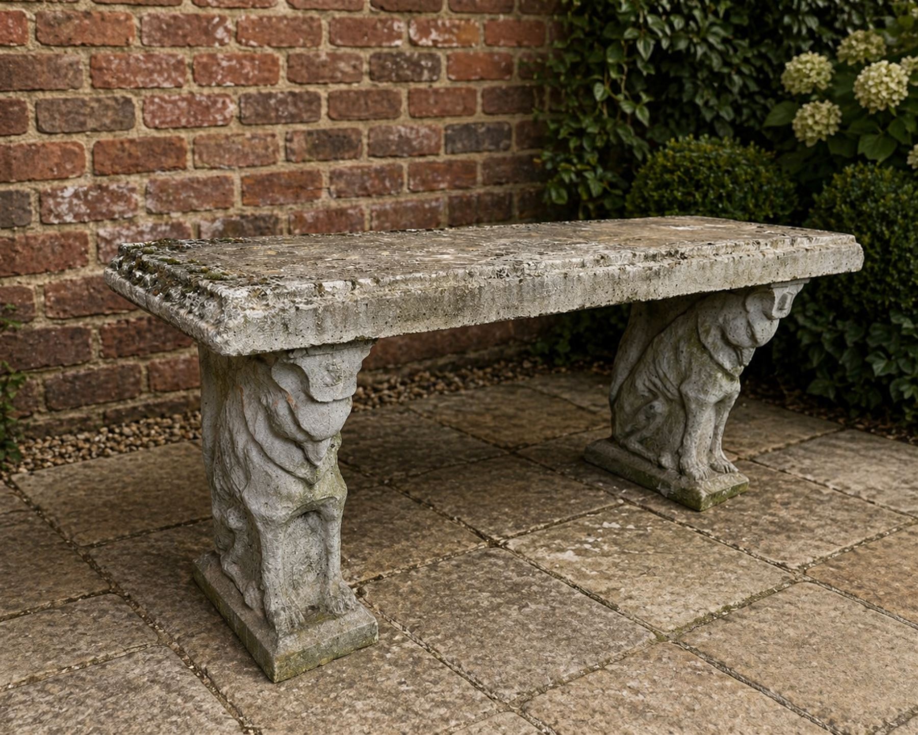 Weathered cast stone three piece garden bench, slab top raised on mythical creature supports