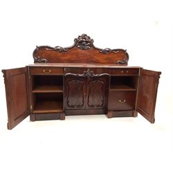 Victorian figured mahogany sideboard, shaped back with carved scroll, floral and fruit cresting, pedestal supports above plinth base, two cupboards opening to reveal interior to include drawers and shelving