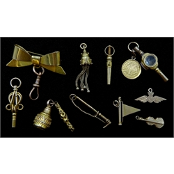  9ct gold ribbon bar brooch hallmarked on 9ct rose gold clip, gold mounted agate watch key with 1 dollar gold coin, two other gold keys and various gold charms including R.A.F, riding crop, flag and violin  