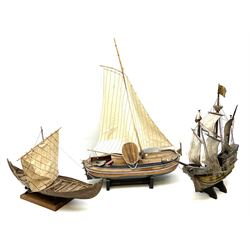Wooden model of an exploration era ship, with three masts, the hull of the caravel painted yellow and with full rigging, together with two wooden model of a sailing boats 