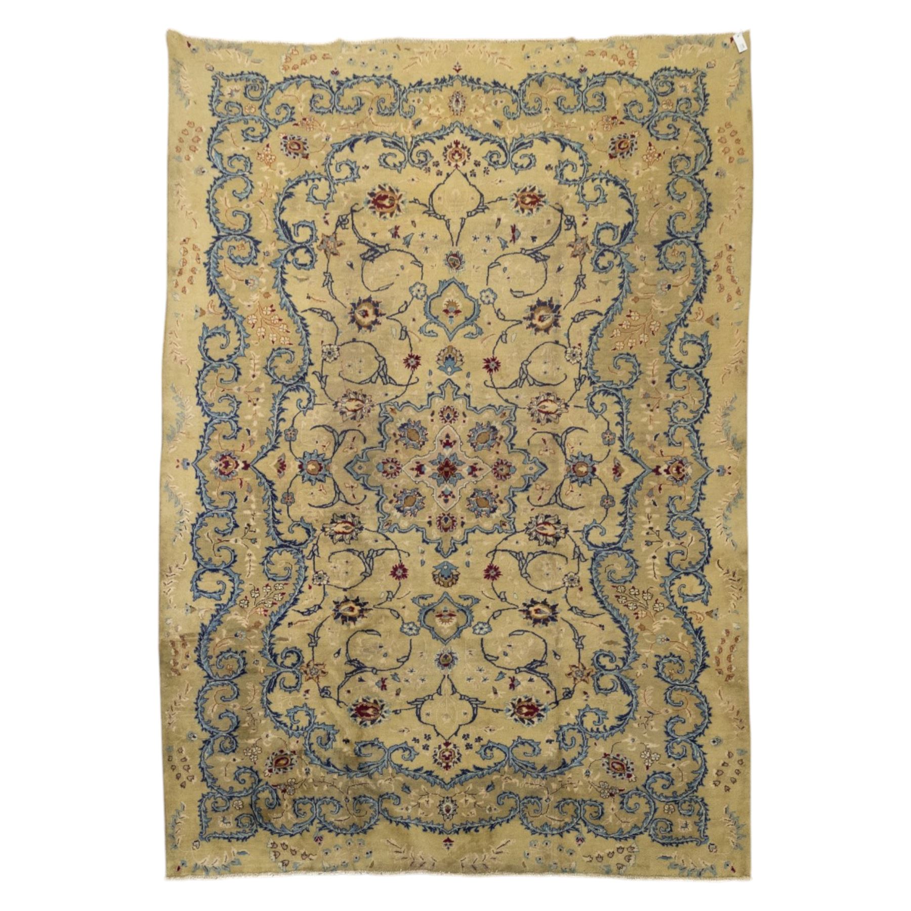 Central Persian Kashan hand-knotted carpet, ivory field with central shaped medallion, surrounded by intricate arrangement of scrolling vine and floral motifs in  pale blue tones, within conforming spandrels and matching border, cotton fringe ends  