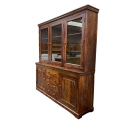 Large hardwood display wall unit, the upper section fitted with three glazed doors enclosing six shelves, the lower section fitted with four central drawers flanked by two panelled cupboards