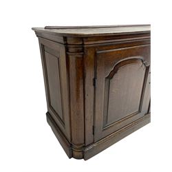 George III oak dresser base, rectangular top with rounded corners over moulded frieze rail, canted corners with turned quarter columns, fitted with three drawers with moulded edges flanked by two cupboards, enclosed by ogee arched fielded panelled doors, panelled sides, moulded plinth base