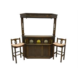 Old Charm - oak corner bar, the canopy frieze carved with scrolls, front decorated with arched apertures glazed with bullseye and mottled glass panes, skirted base, together with two bar stools