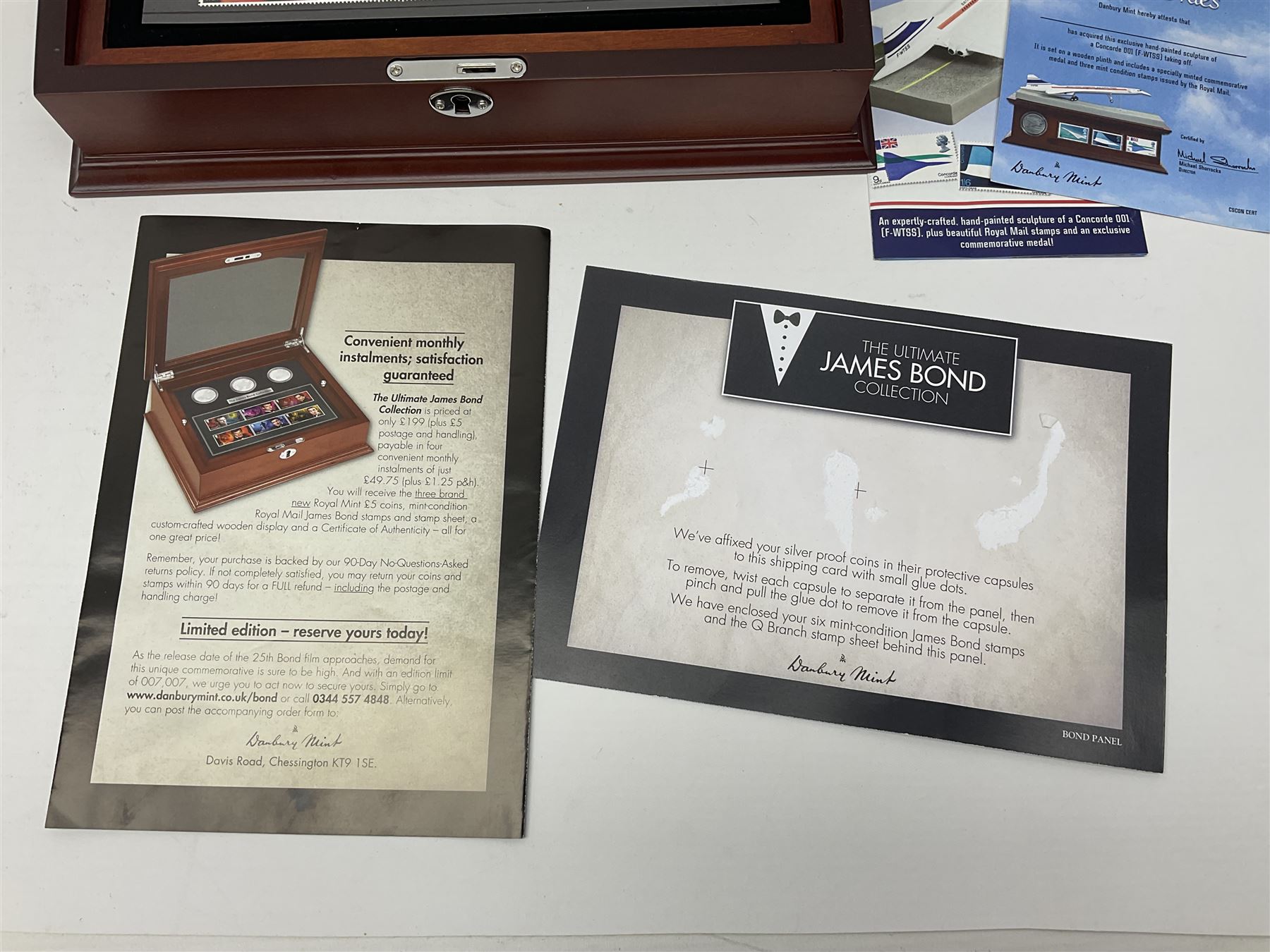 Danbury Mint 'The Ultimate James Bond Collection' comprising stamps and coins housed in a display case, 'Concorde Queen of the Skies' sculpture, stamps, medallion display and 2020 'Centenary of the Unknown Warrior' five pound coin cover in Harrington and Byrne folder