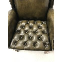 Georgian style wing back armchair upholstered in deep buttoned and studded green leather, square supports 