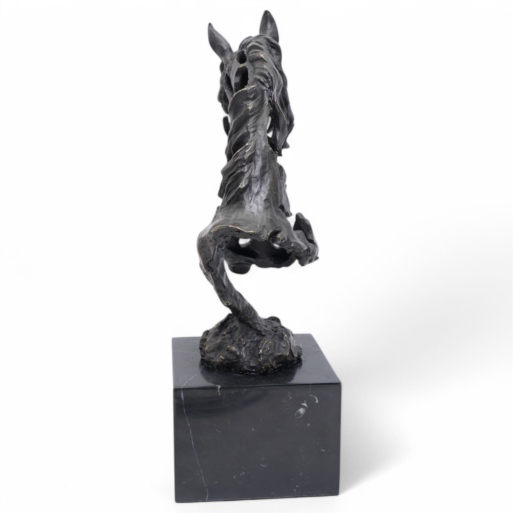 Bronze figure, modelled as a stylised horses head, upon a square marble plinth, signed and bearing foundry mark, overall H41cm
