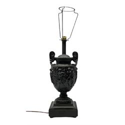 Neo classical style black painted twin handled lamp, decorated with classical scenes, with pedestal base raised upon shaped stepped square plinth, H62cm overall