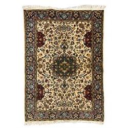 Persian ivory ground rug, central green floral pole medallion within a field decorated by scrolling foliate patterns, the guarded border with repeating palmettes and floral designs