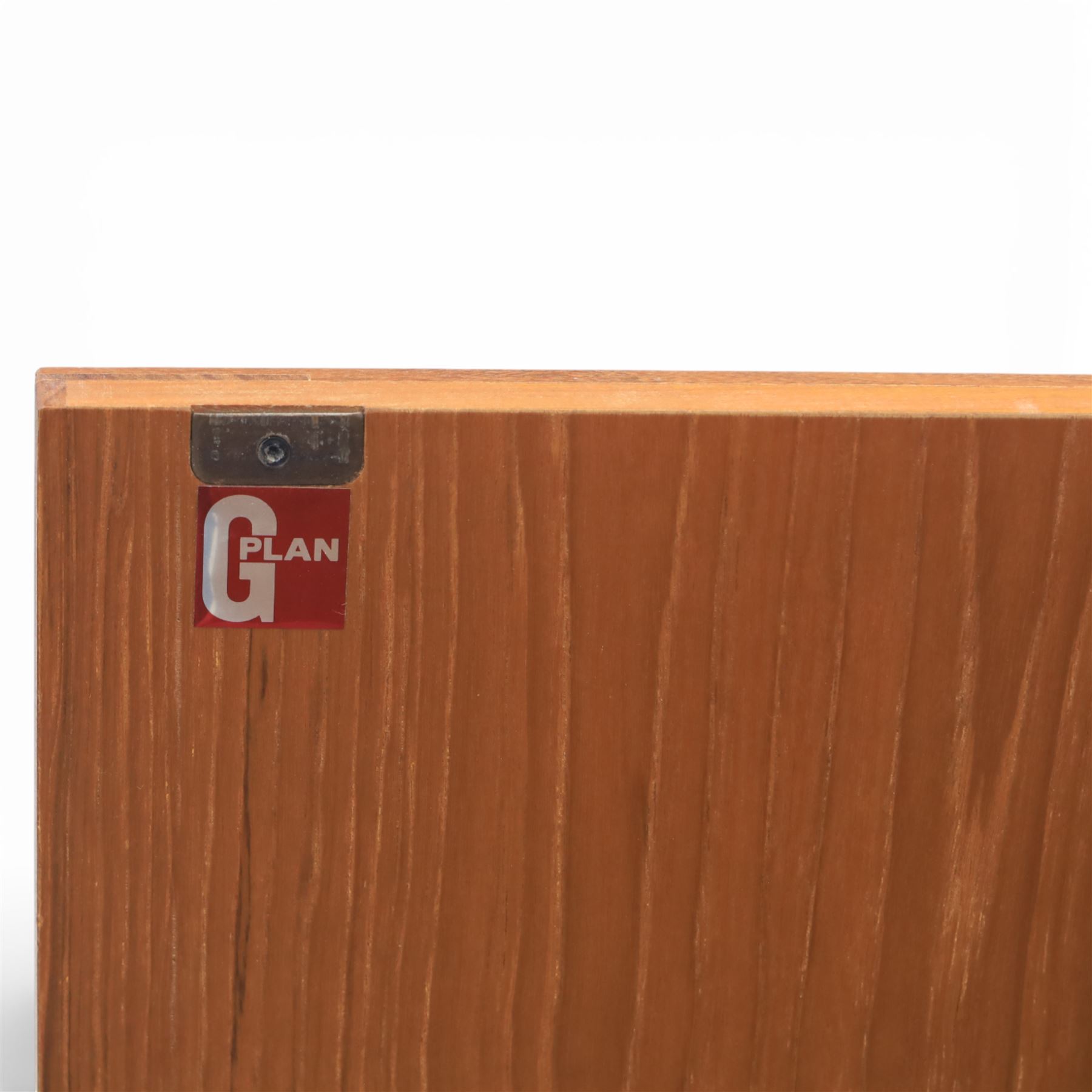 G-Plan - ‘Brasilia’ teak sideboard, rectangular top with moulded edge above a central bank of four drawers flanked by cupboard doors with carved sculptural handles, raised on tapering supports
