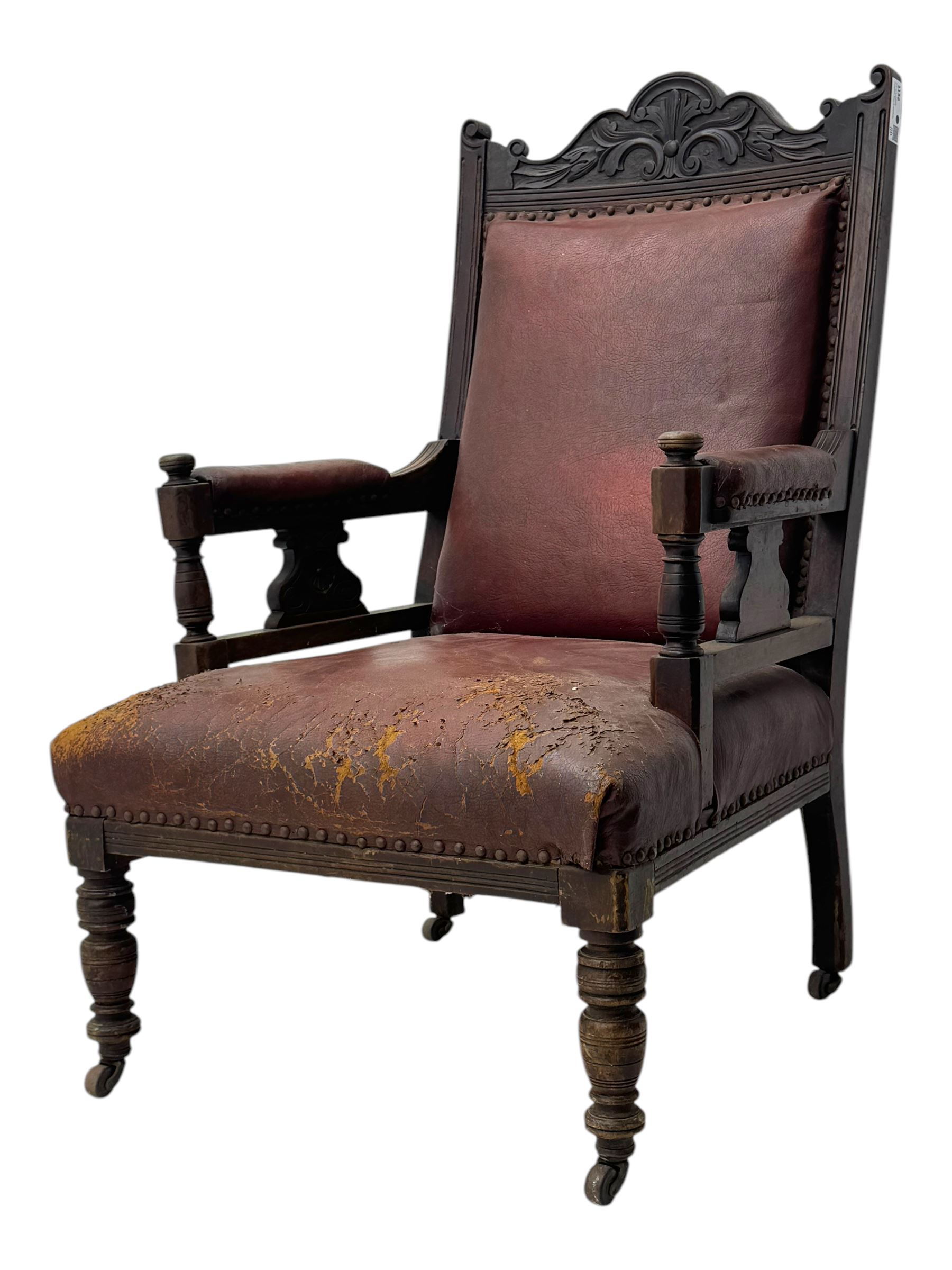 Victorian walnut framed armchair, shaped pediment carved with scrolling foliage, upholstered in leather, on ring turned front feet