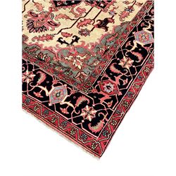 North West Persian Heriz carpet, ivory ground with large central medallion and floral spandrels, triple band border with scrolling design decorated with flower head and plant motifs 