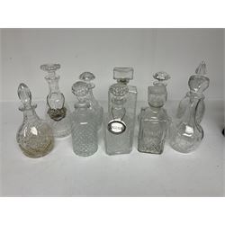 Ten decanters to include an I.W. Harper example of concave square form and two examples with tags, all with stoppers