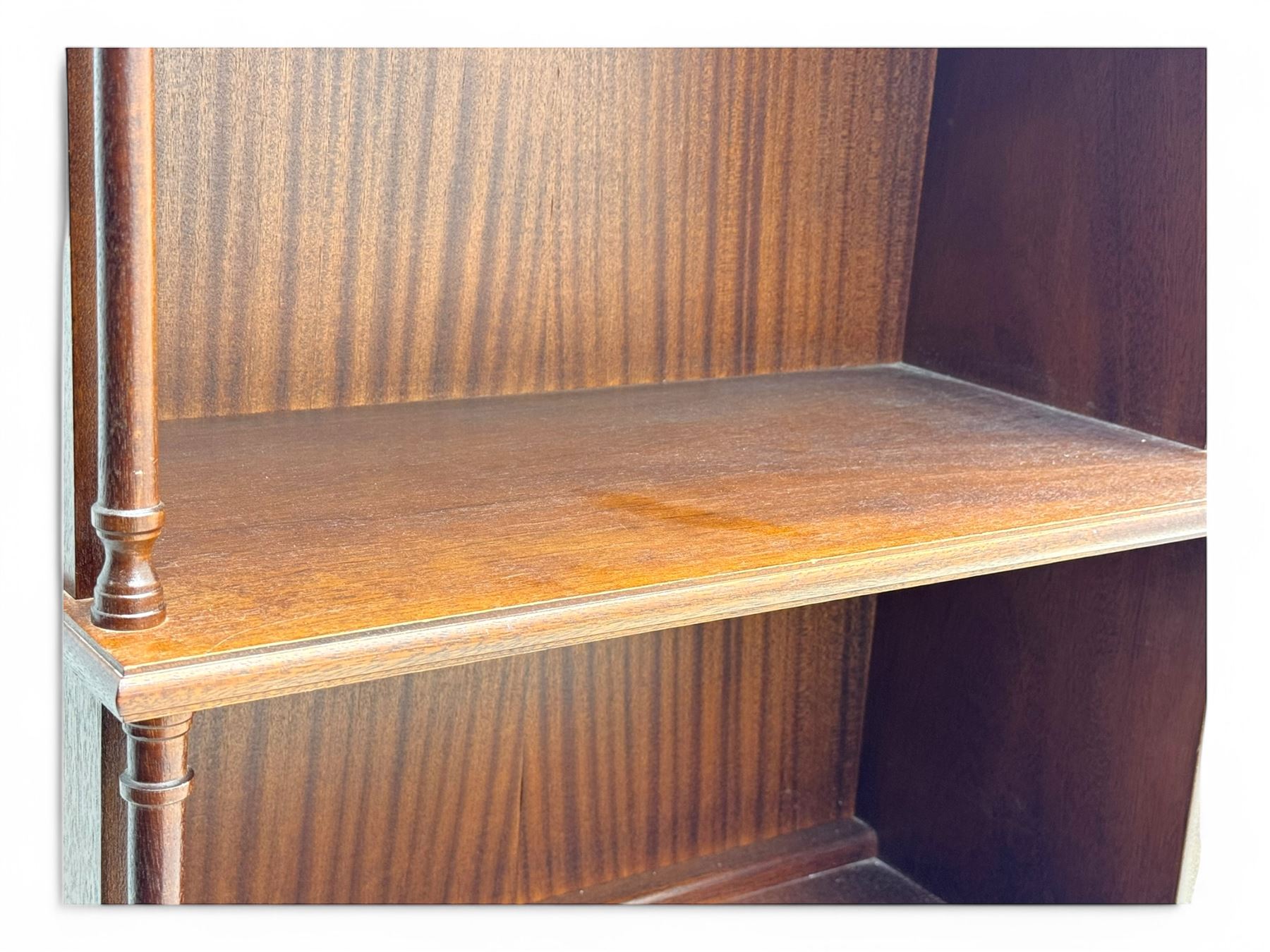 Mid-20th century mahogany open bookshelf, the rectangular top with a brass balustrade gallery, over three shelves each supported by turned column uprights, on shaped apron base