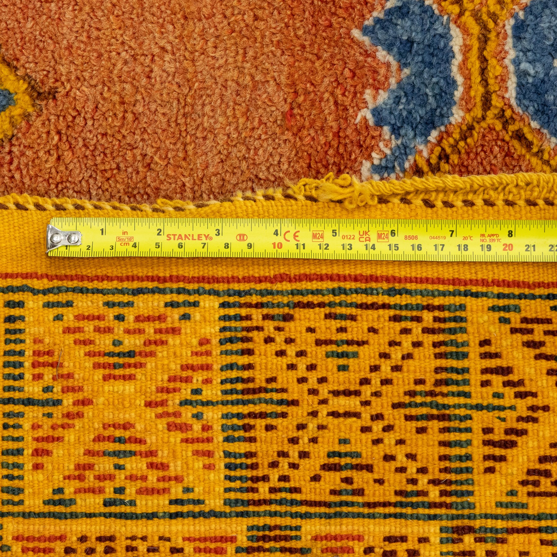 Turkish Anatolian hand-knotted carpet, salmon ground centred by a blue and cream octagonal medallion, scattered with geometric floral and tribal motifs, cream spandrels and yellow geometric border