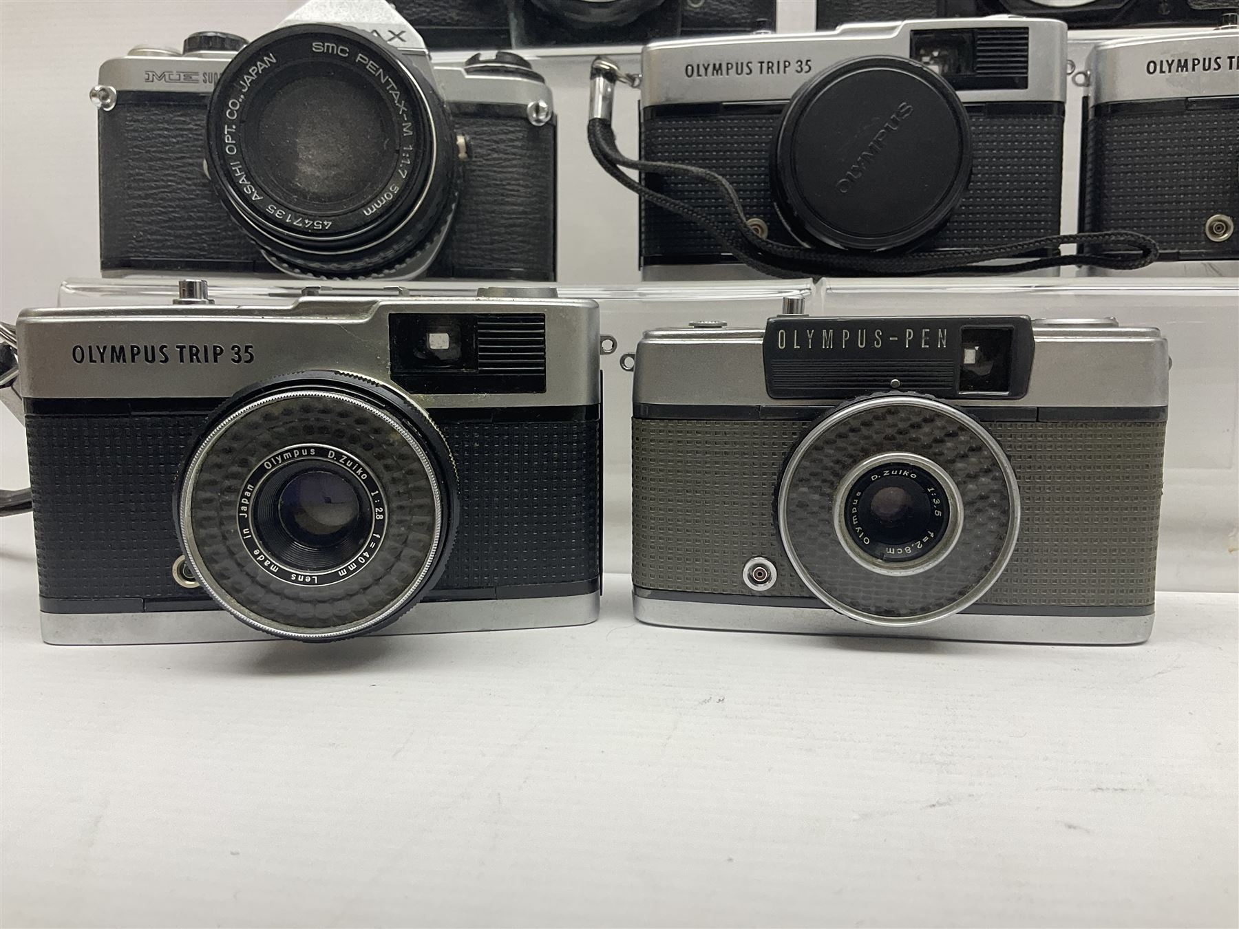 Olympus Pen-EE camera, serial no 415299, with Olympus D.Zuiko 1:3.5 f=2.8cm lens, together with four Olympus Trip 35 cameras, serial nos 4759245, 4257589, 1847727 and 5387611, each with Olympus D. Zuiko 1:28 f=40mm lenses