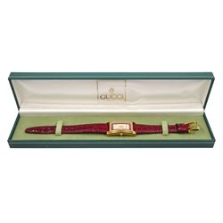 Gucci gold-plated rectangular quartz wristwatch, Ref. 2600M, red and silvered dial, on original red leather strap, boxed