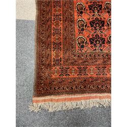 Large Afghan Turkman carpet, terracotta field decorated with repeating stylised plant motifs, multiple band border 