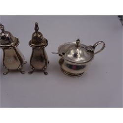 1920s silver two piece cruet set, comprising mustard pot and cover and open salt, of circular form with shaped rim, hallmarked William Suckling Ltd, Birmingham 1924, with blue glass liners and two matched hallmarked silver condiment spoons, together with a pair of silver pepper shakers, of typical baluster form, engraved with initial, upon four pad feet, hallmarked Walker & Hall, Birmingham 1918